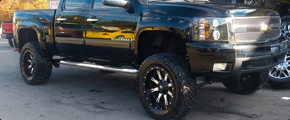 Chevy Silverado with Lift Kit, Mud Tires, Fender Flares and LED Headlights.